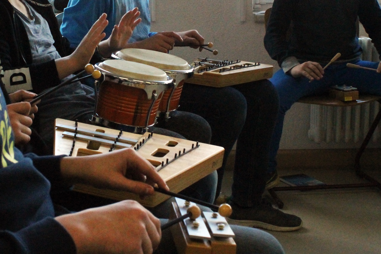 Jugendliche spielen auf Bongos und anderen Instrumenten.