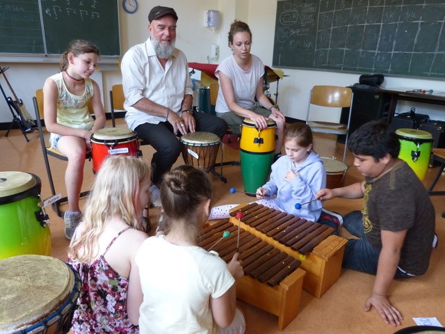 Kinder in einem Klassenzimmer beim Musizieren.